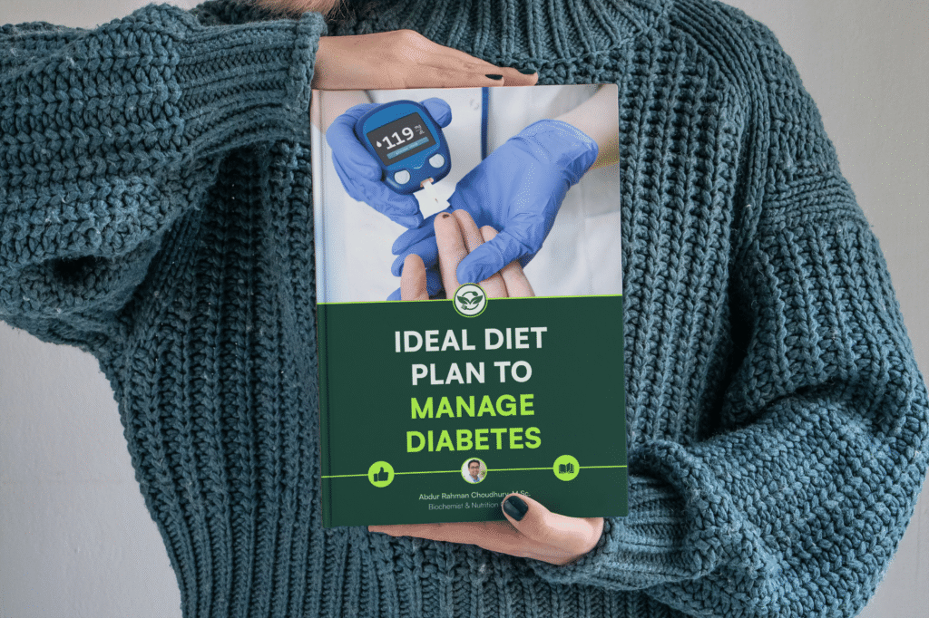 Person in knit sweater holding diabetes diet plan ebook against chest with glucose meter cover visible